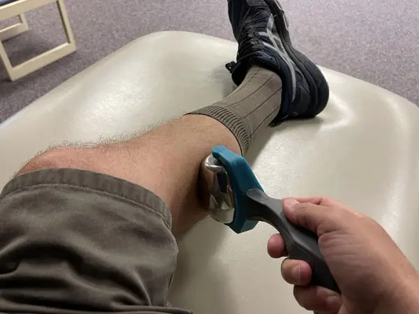 Massaging Calf with Massage Roller After Knee Surgery